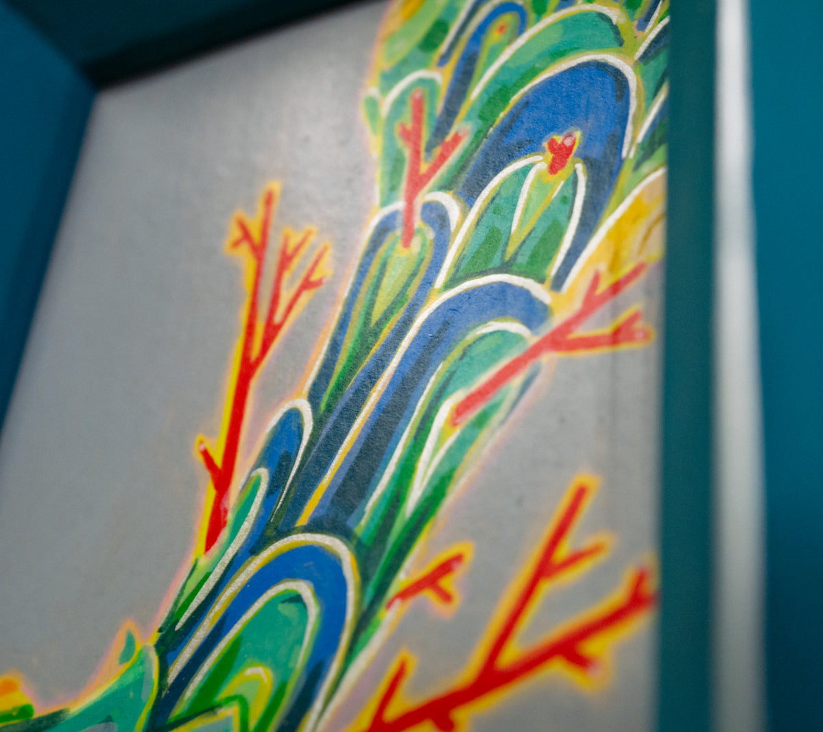 Angled close-up of Formation in its teal frame, showing the layered scales and bright red branches.