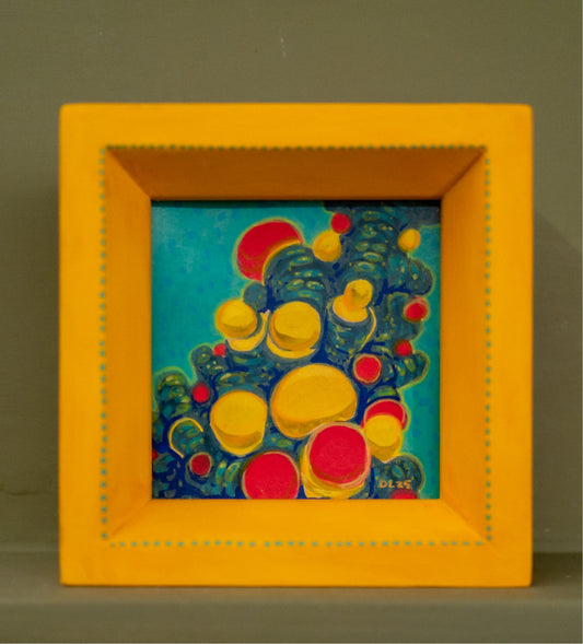 Tiny square acrylic painting of yellow and red bubbles clustered on teal and blue growth, in a handmade yellow frame with painted teal dots.